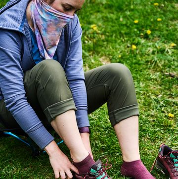 woman wearing hiking socks and putting on a pair of hiking shoes