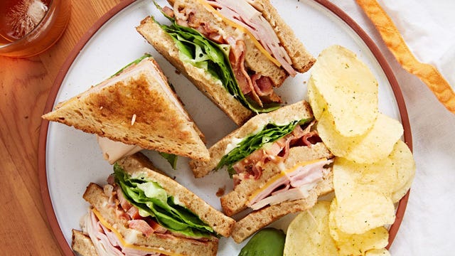 club sandwich layered with tomato, turkey, ham, bacon, and lettuce