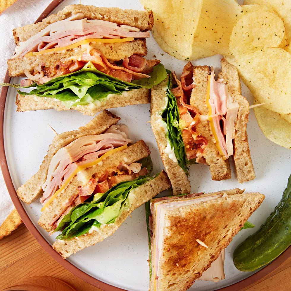 club sandwich layered with tomato, turkey, ham, bacon, and lettuce