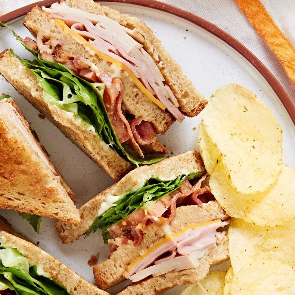 club sandwich layered with tomato, turkey, ham, bacon, and lettuce