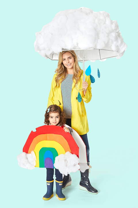 mom halloween costume with rain clouds umbrella and yellow rain coat beside rainbow child costume