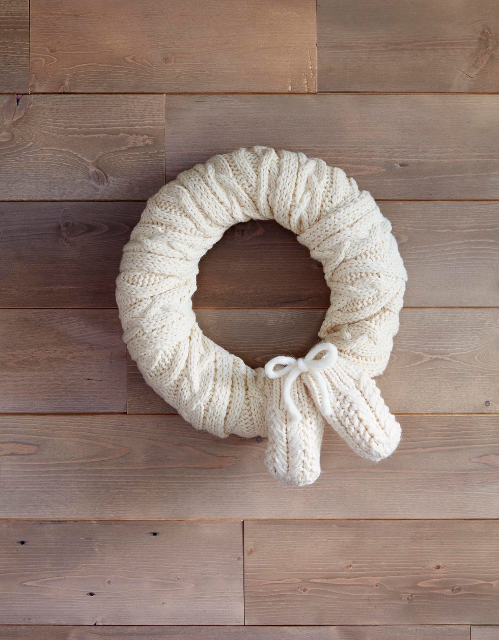 wreath made from white knit scarf on wood wall