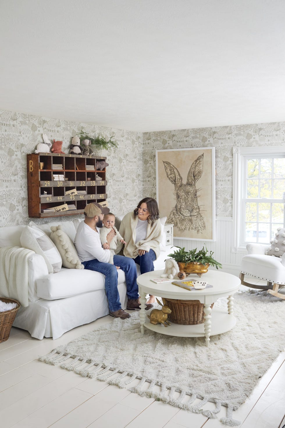 neutral nursery with white sofa and toile wallpaper