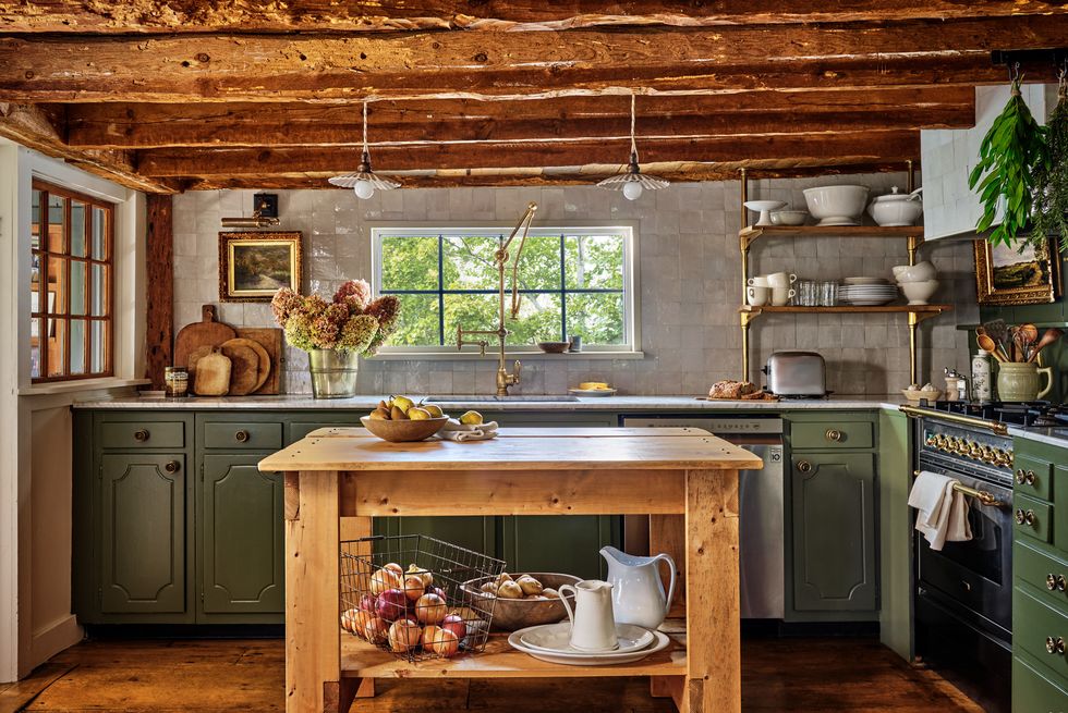 cottage kitchen with low ceilings and wood beams, white tile backsplash, and green cabinets