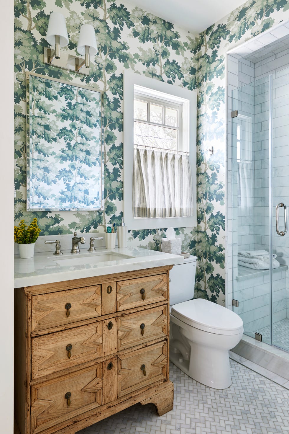 bathroom with green floral wallpaper and white tile wainscoting with black tile trim