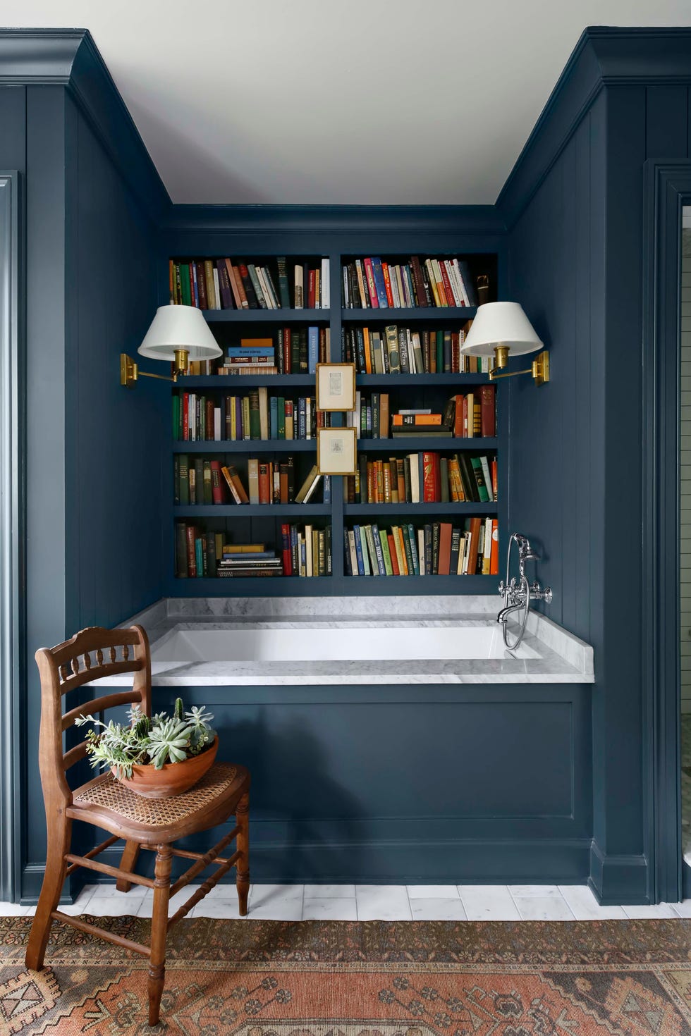 brass light sconces and bookshelf in bathroom of country home