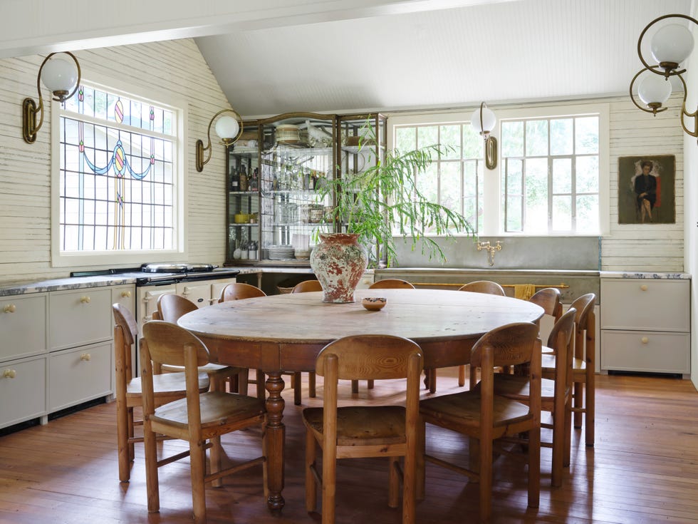 white cottage kitchen with large round wood dinner table