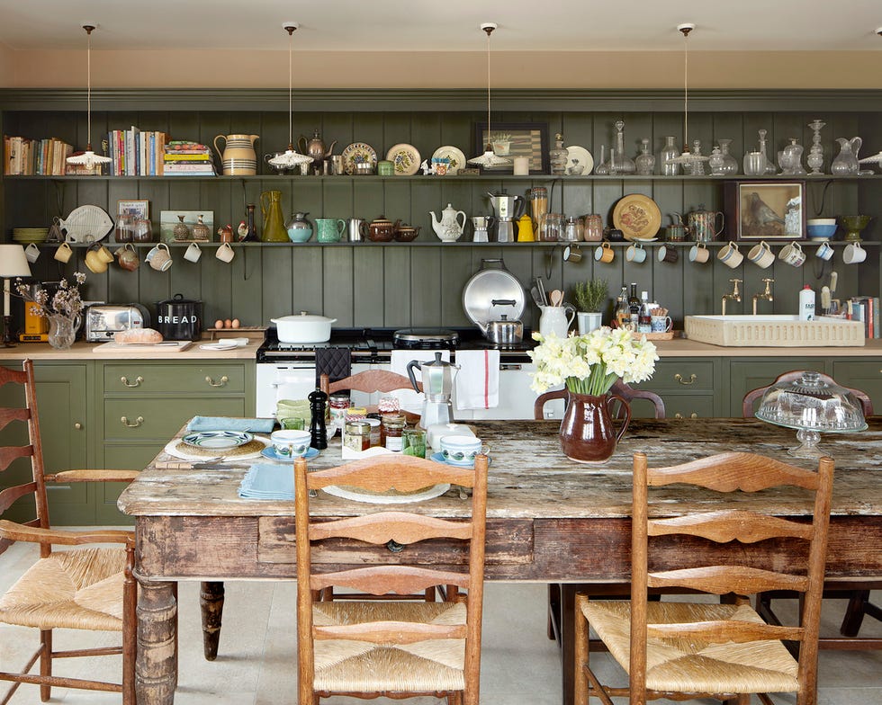 kitchen with green cabinets and open shelving workhorse tables