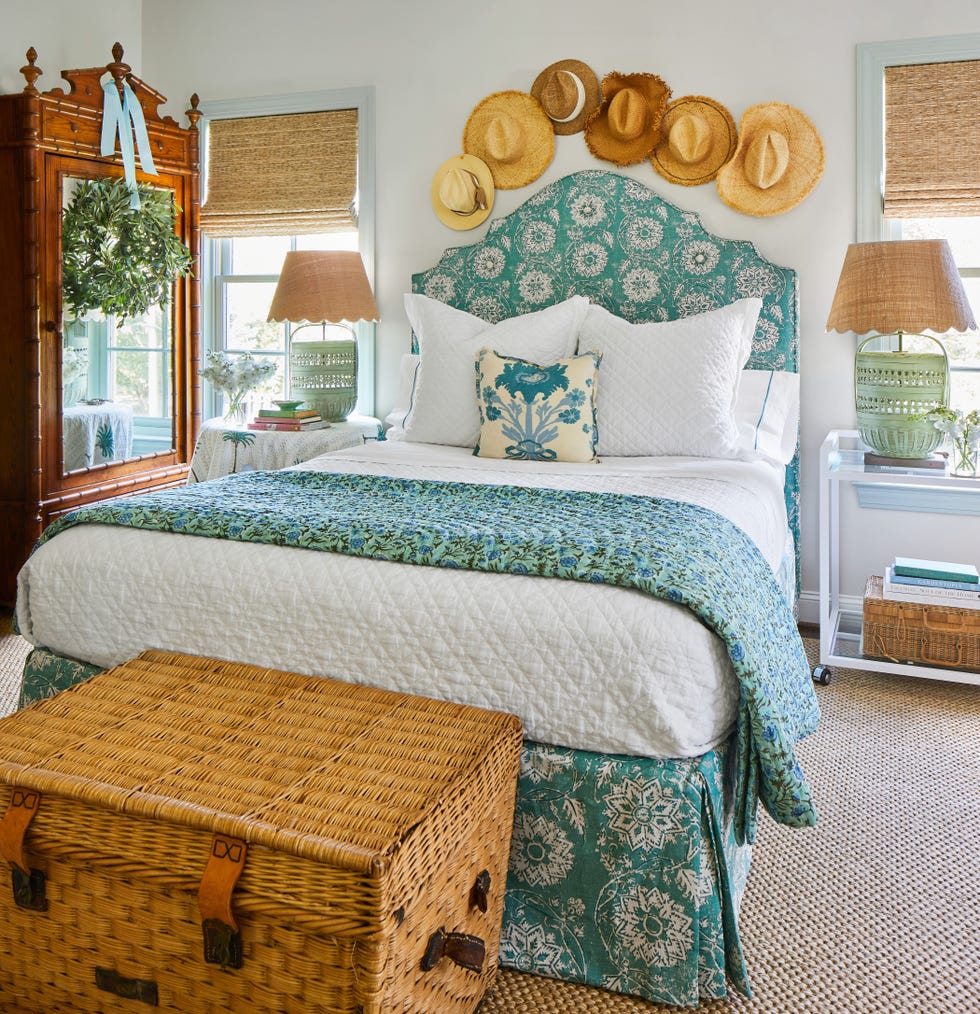 bedroom decorated with straw hats on wall. blue bedding.
