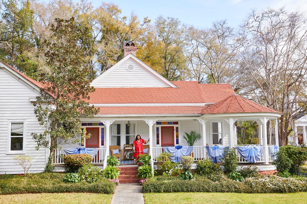 white house with wraparound porch with blue bunting