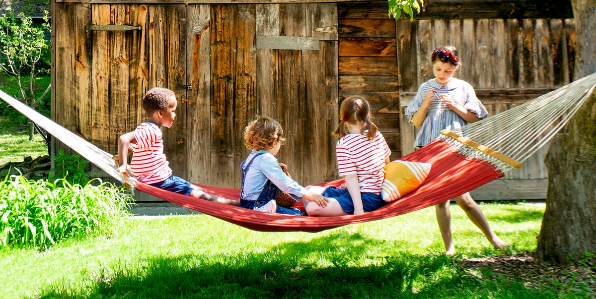 kids on a hammock in front of a barn kids on a hammock in front of a barn