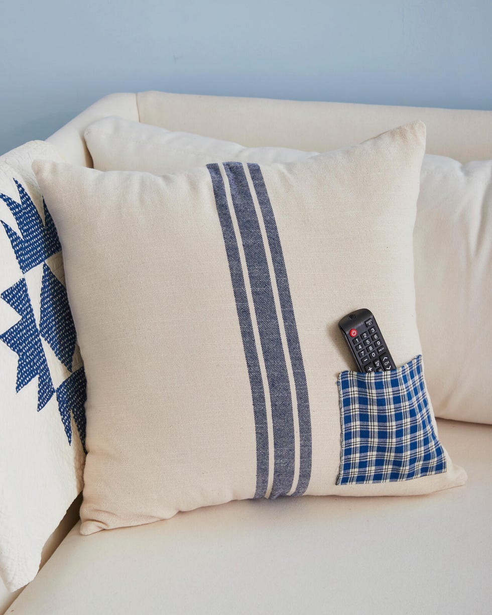 A pillow with a fabric pocket sewn into the front for storing a TV remote control