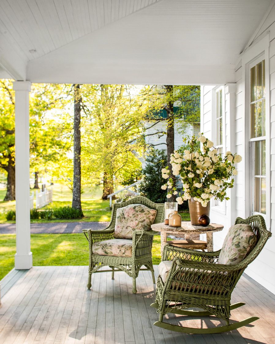 green wicker rocking chairs with floral upholstery look out over a porch