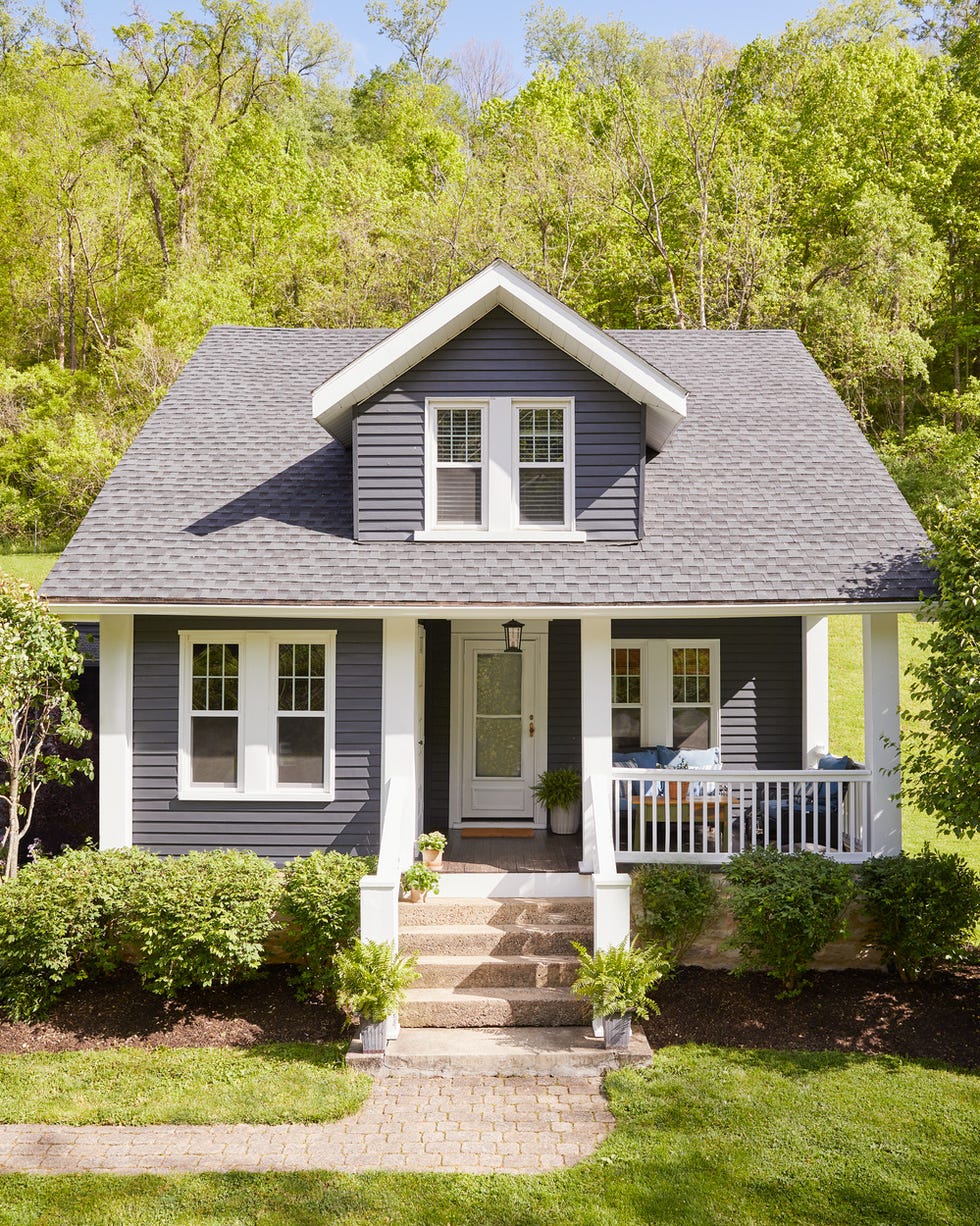 1920s bungalow exterior with small plants and a sitting area 1920s bungalow exterior with small plants and a sitting area