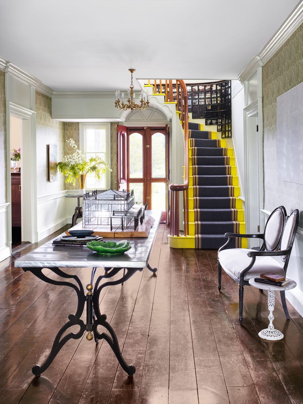 entryway with a grand staircase painted with canary yellow on stair treads