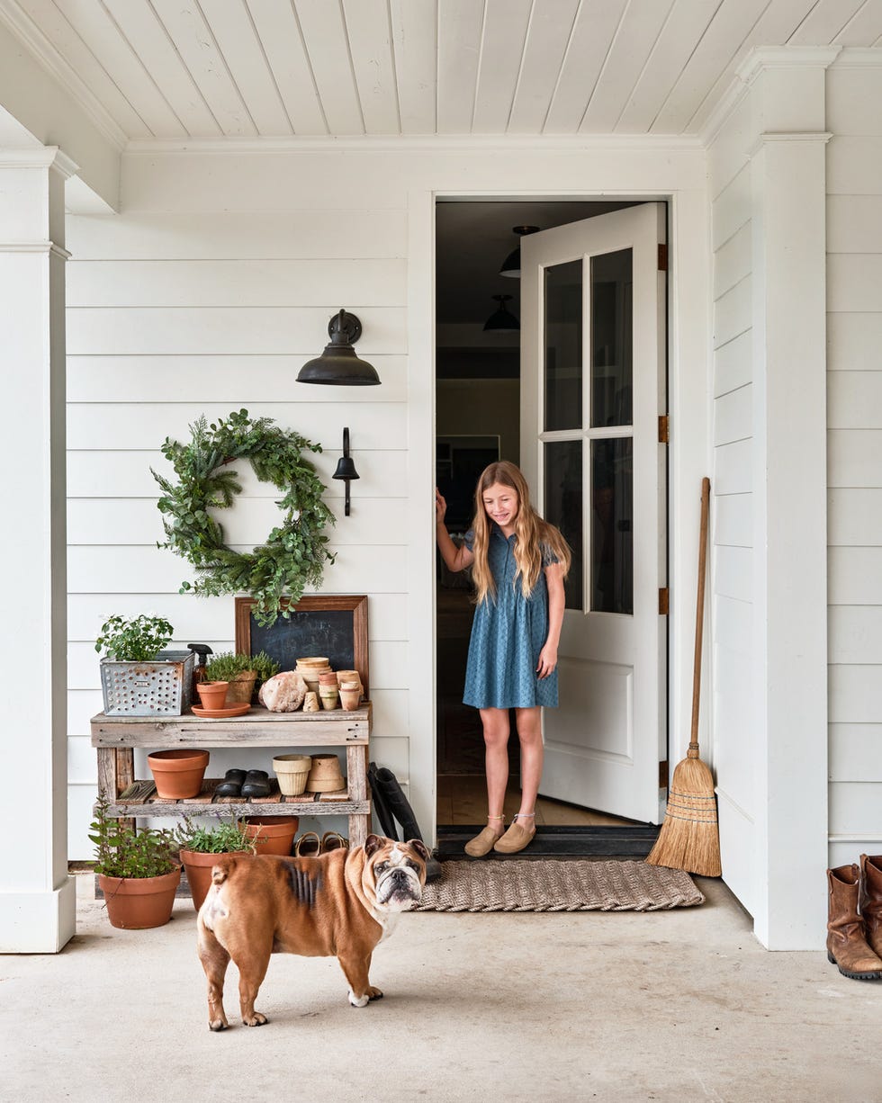 potting station porch with a potting station next to door and girl and dog standing