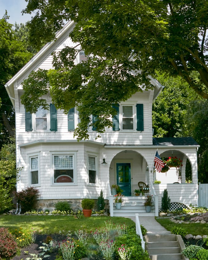 designer erick espinozas 1895 victorian home in danbury, connecticut the exterior is all white with green trim