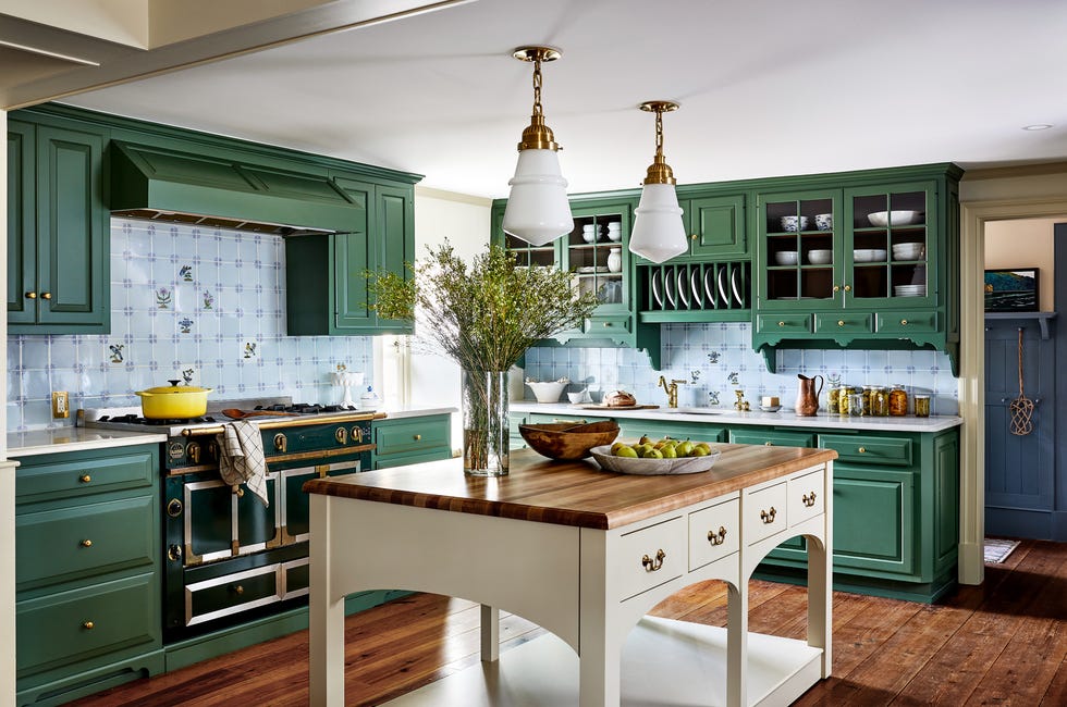 kitchen with green cabinetry, a white island with wood top, and blue backsplash tile