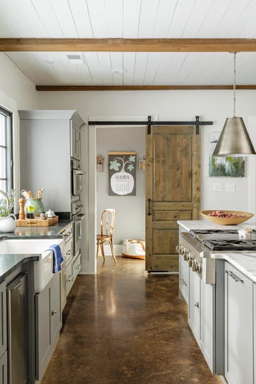 a kitchen with a sliding barn door leading into office