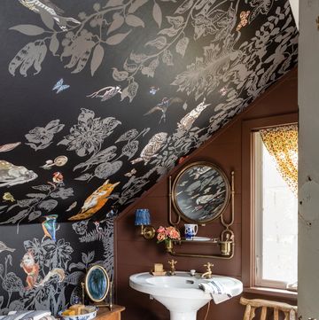 sloped roof bathroom with dark woodland creature themed wallpaper