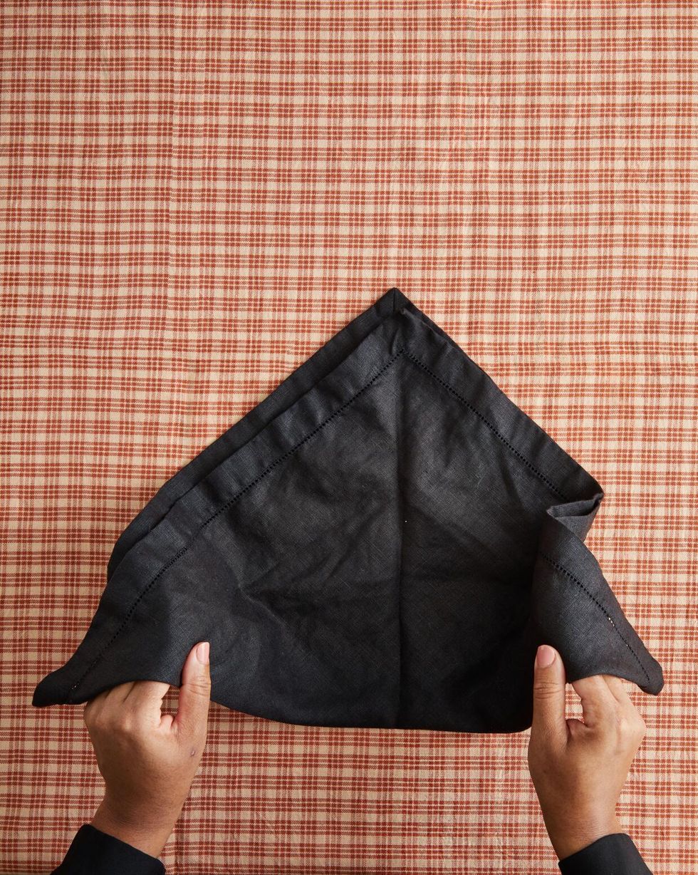 hands holding a black napkin on a table