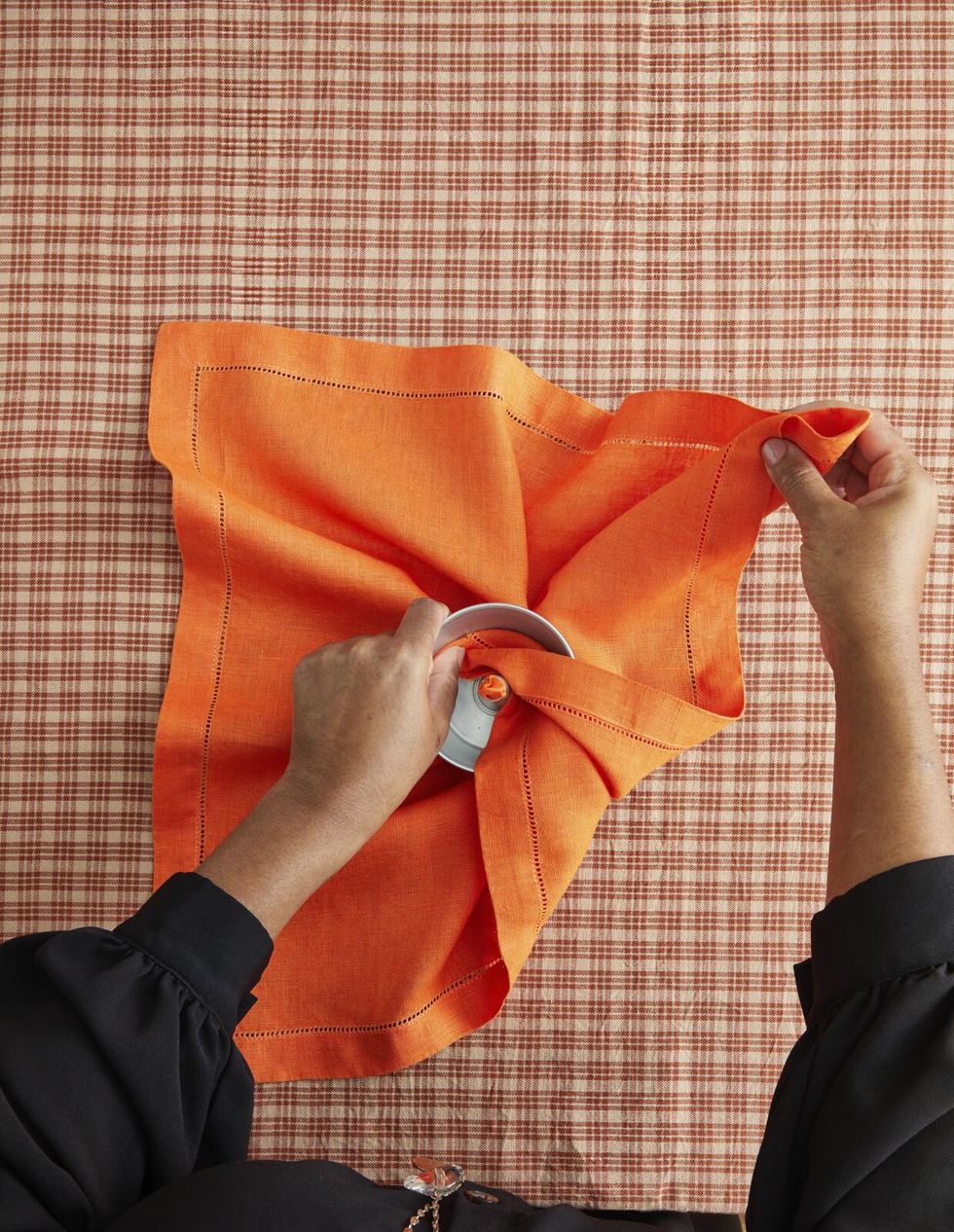hands hold orange napkin and bundt pan
