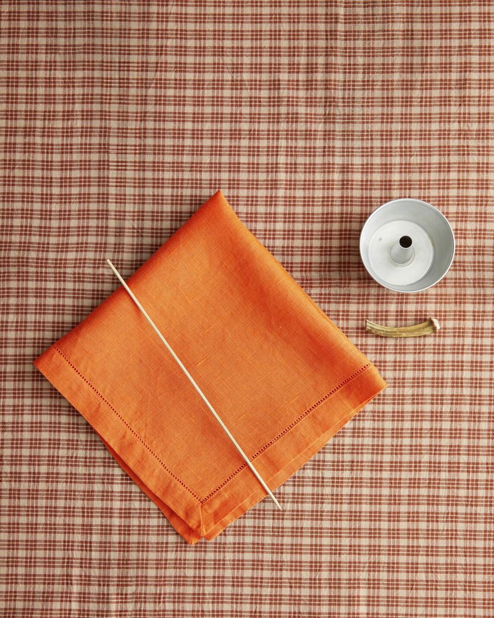 orange napkin dowel rod small bundt pan and old pumpkin stem sit on top of a table