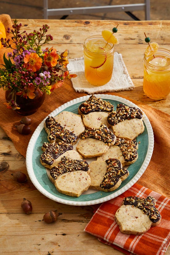 shortbread cookies cut to the shape of acorn coated in melted chocolate and chopped pecans