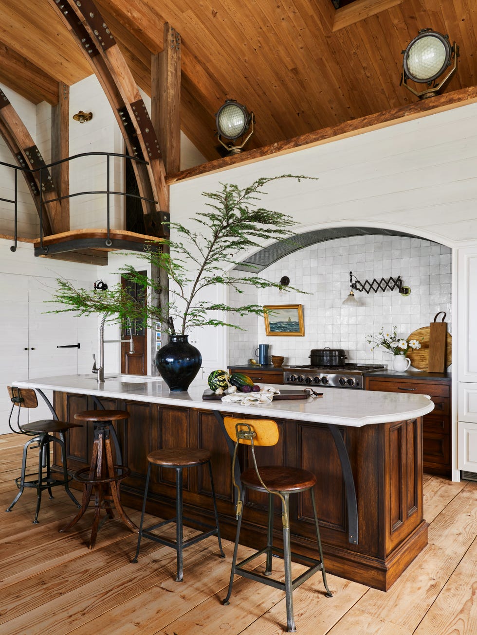 industrial barn kitchen with white tile, wood, and marble countertops, island made from dark antique wood