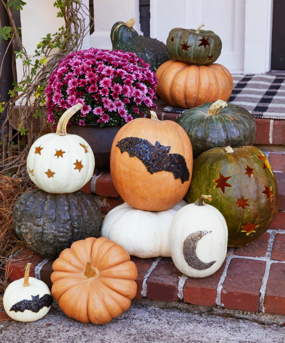 pumkins on a front porch some decorated with star cutout and others with bat and moon shapes made from nails