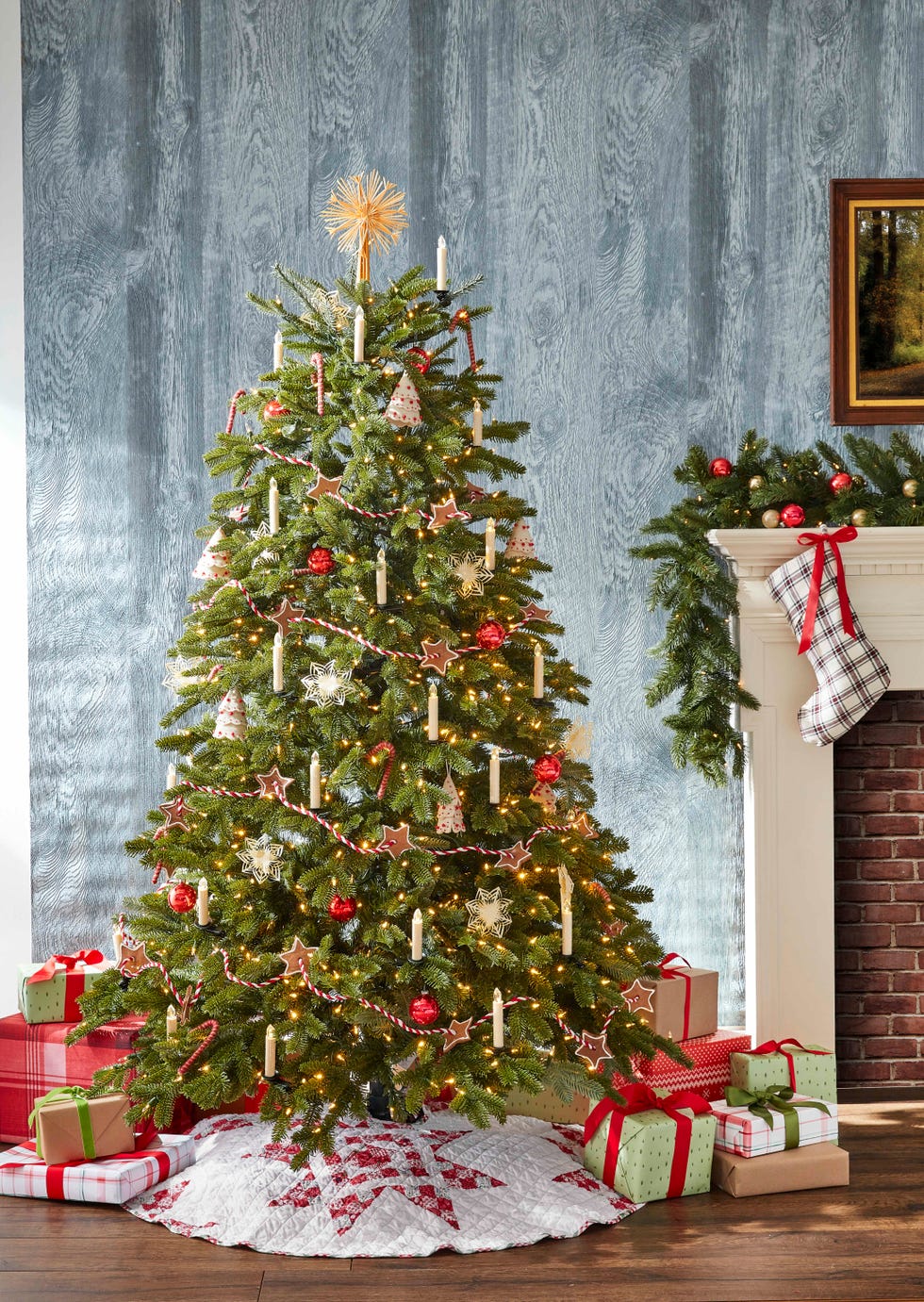 traditional christmas tree decorated with gingerbread start garlands, faux candles, presents wrapped in plain brown, red, and green papers