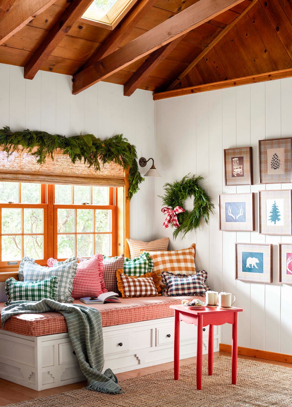 a white built in bench with plaid cushion and piles of checked pillows