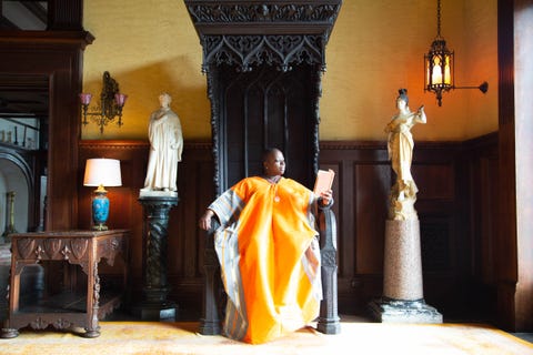 nona faustine's photograph of a woman reading on a carved wooden throne