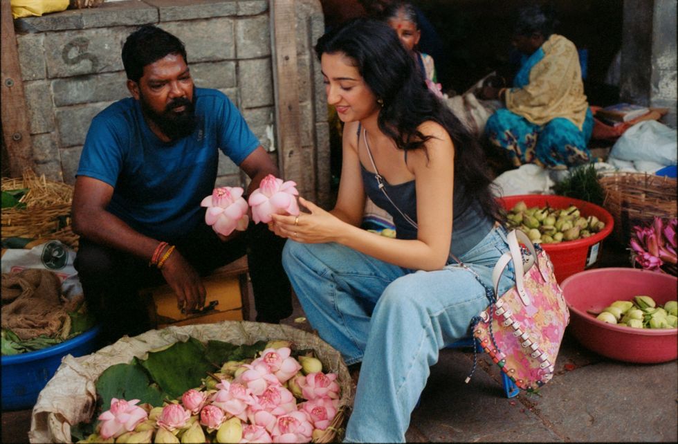 a man and woman sitting next to each other holding flowers
