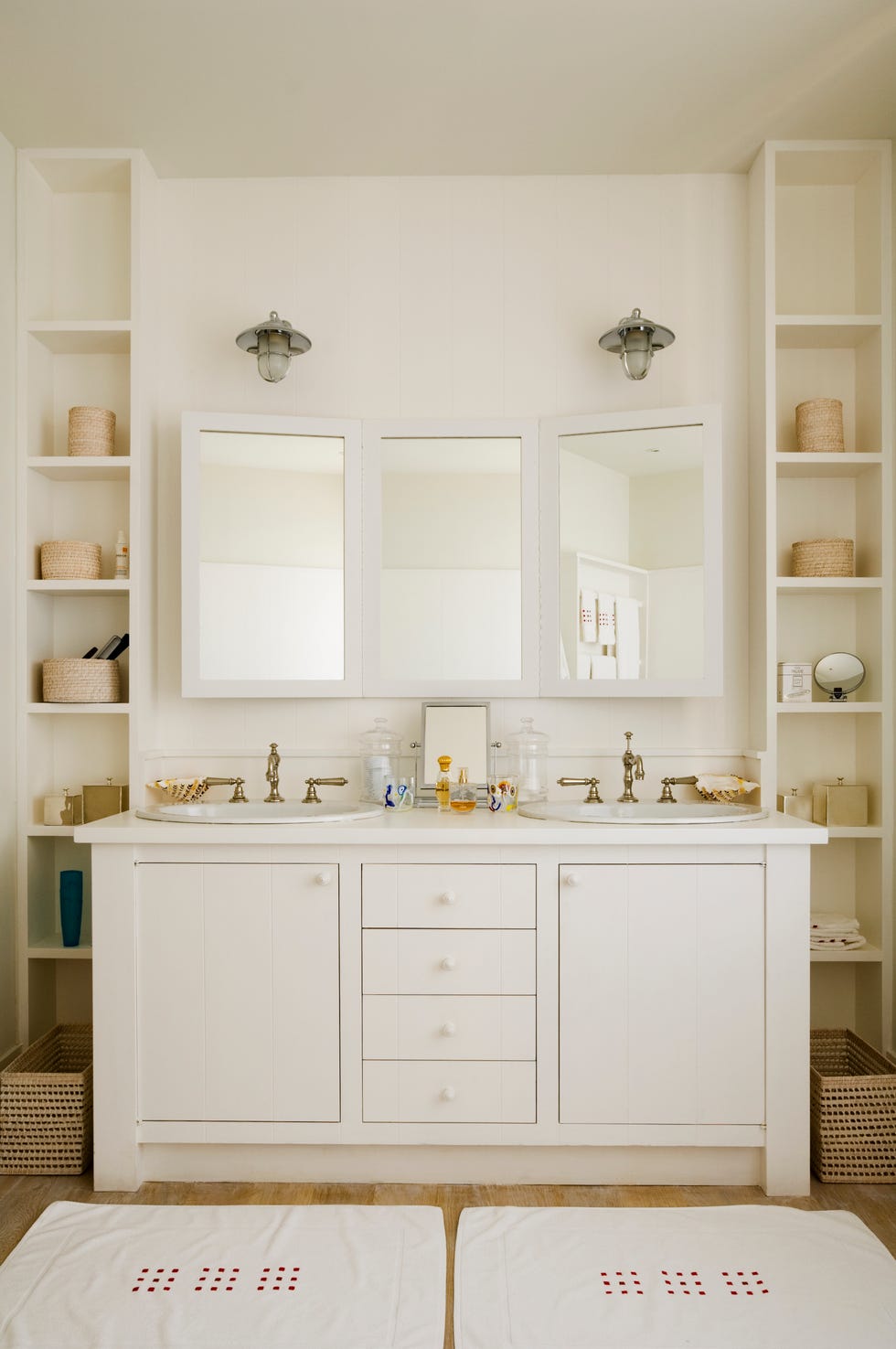 bathroom with two sinks bathroom with two sinks, two floor to ceiling built in shelves, two mats, and other symmetrical elements