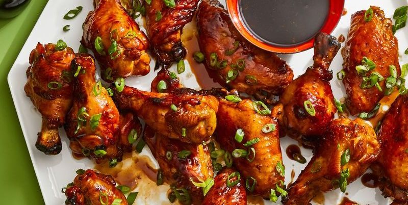 cola glazed chicken wings with sauce on a white platter