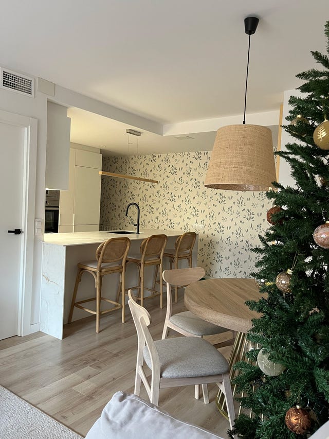 cocina abierta al comedor con barra y papel pintado botánico