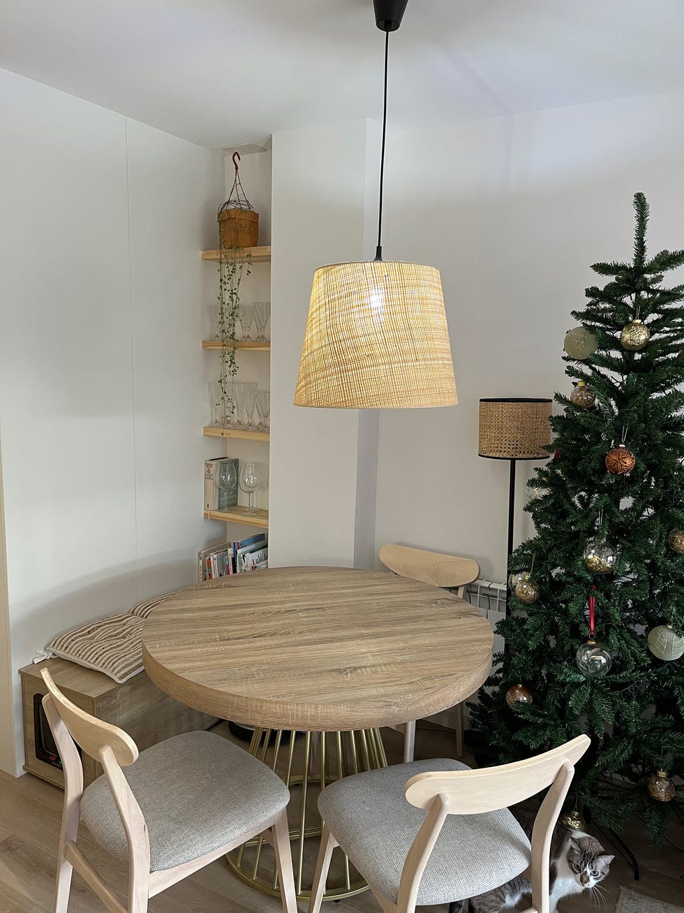 comedor con mesa redonda y sillas de madera con asientos de tela gris