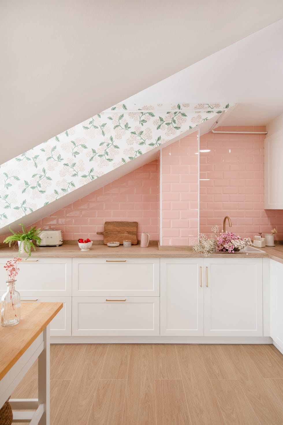 cocina con armarios blancos y frente de azulejos rosas