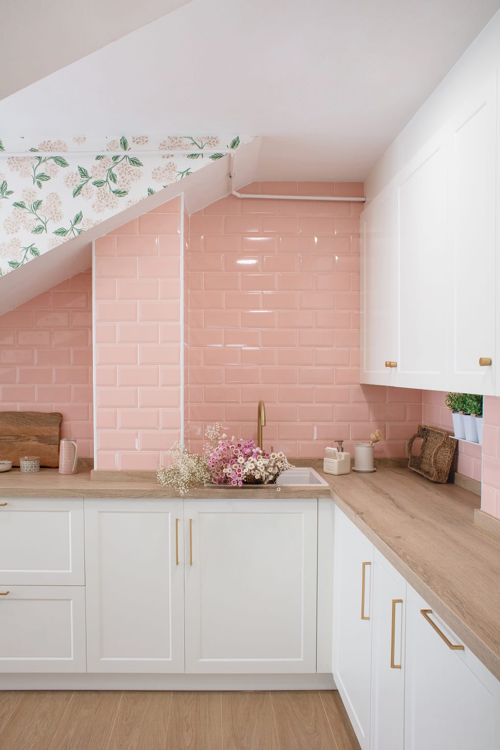 cocina con armarios blancos y frente de azulejos rosas