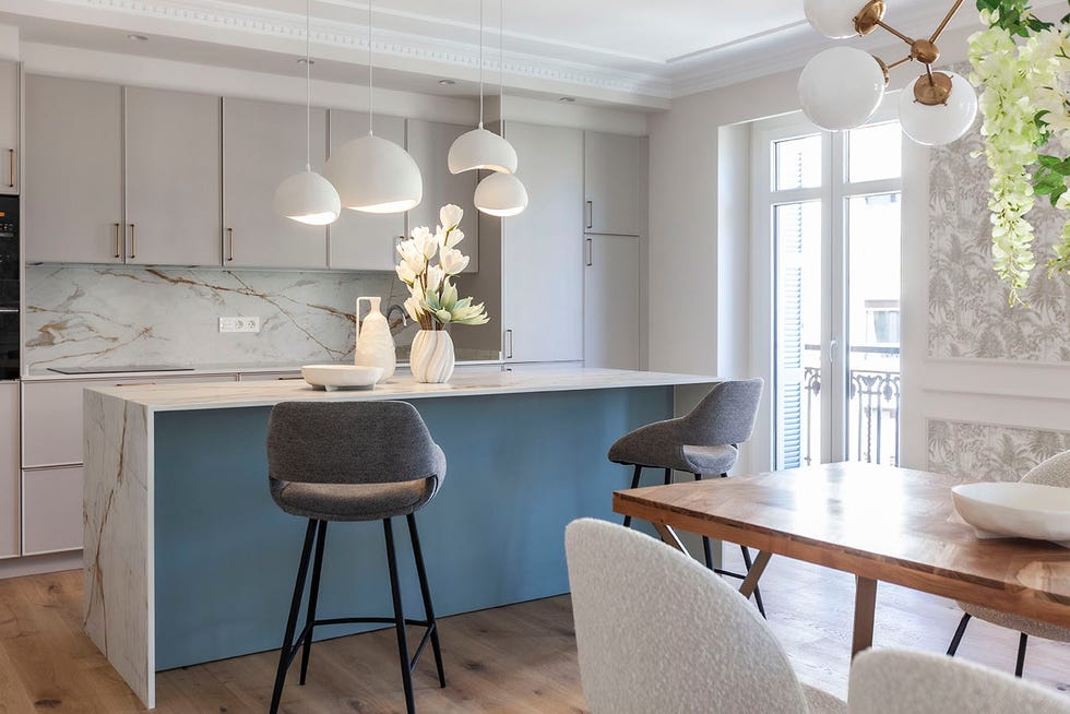 cocina en blanco y azul con isla y taburetes