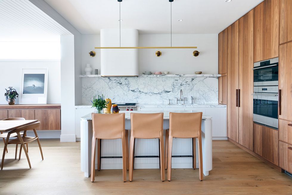 Cocina de estilo minimalista se puede ver un pequeño refrigerador blanco  junto a una ventana, una mesa de comedor con asientos blancos, estantes para  vajilla y una habitación vacía