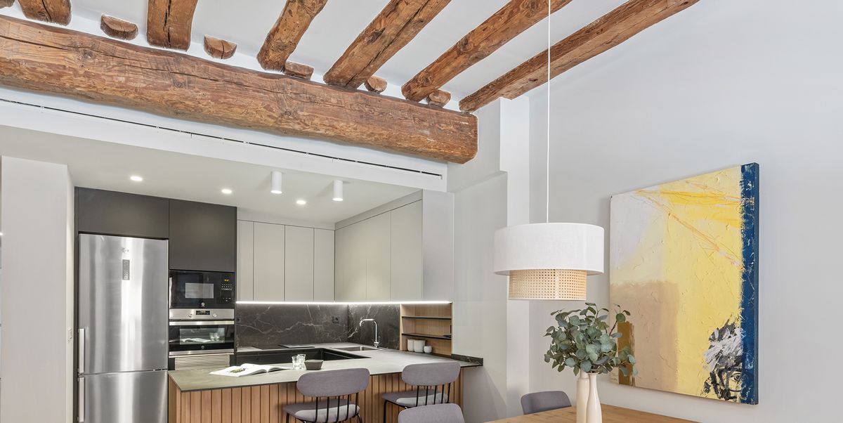 Un apartamento con cocina abierta y vigas vistas de madera