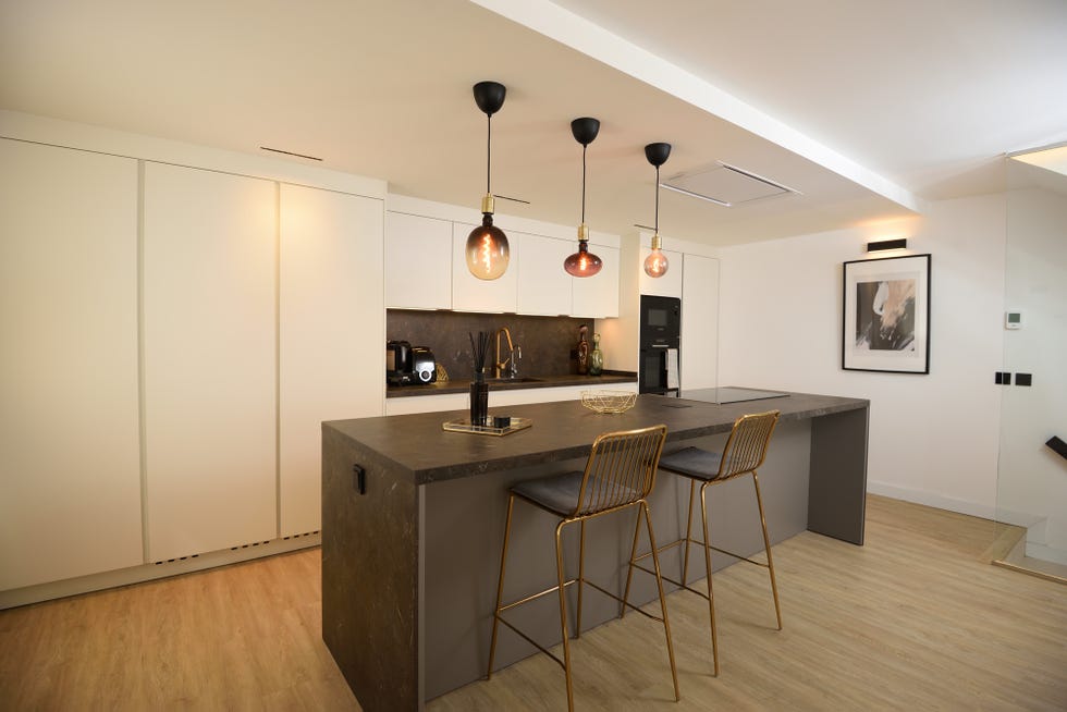 cocina moderna con isla central y taburetes dorados