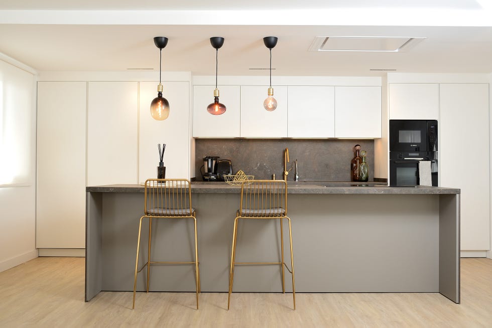 cocina moderna con isla central y taburetes dorados