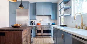 cocina azul con isla central de madera y estilo retro