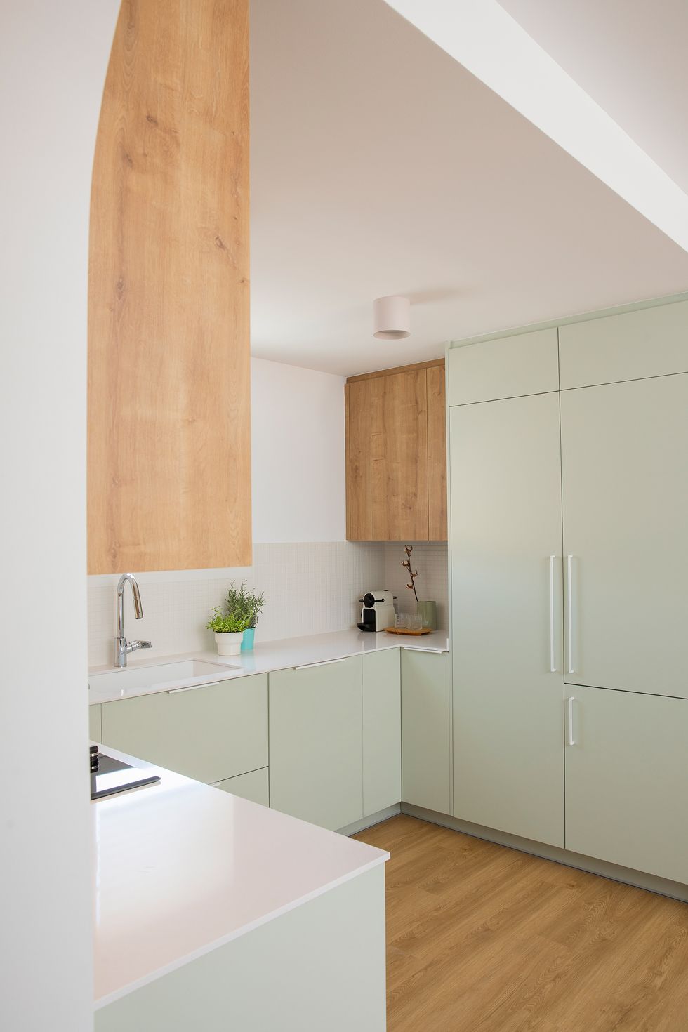 cocina de color verde empolvado con armarios superiores de madera