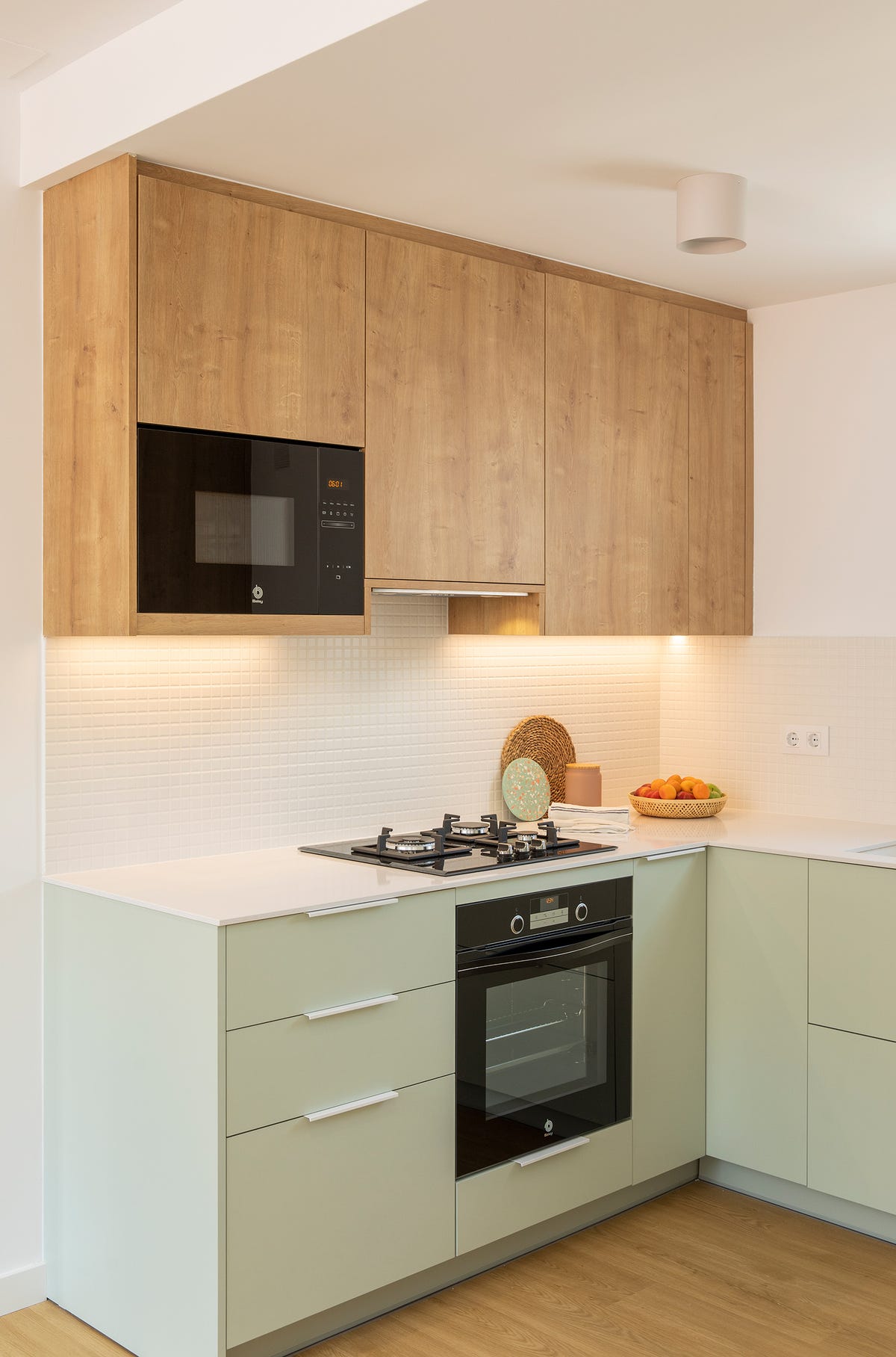 cocina de color verde empolvado con armarios superiores de madera