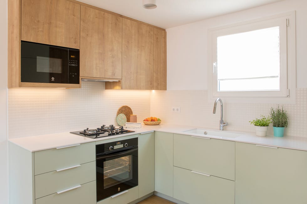 cocina de color verde empolvado con armarios superiores de madera