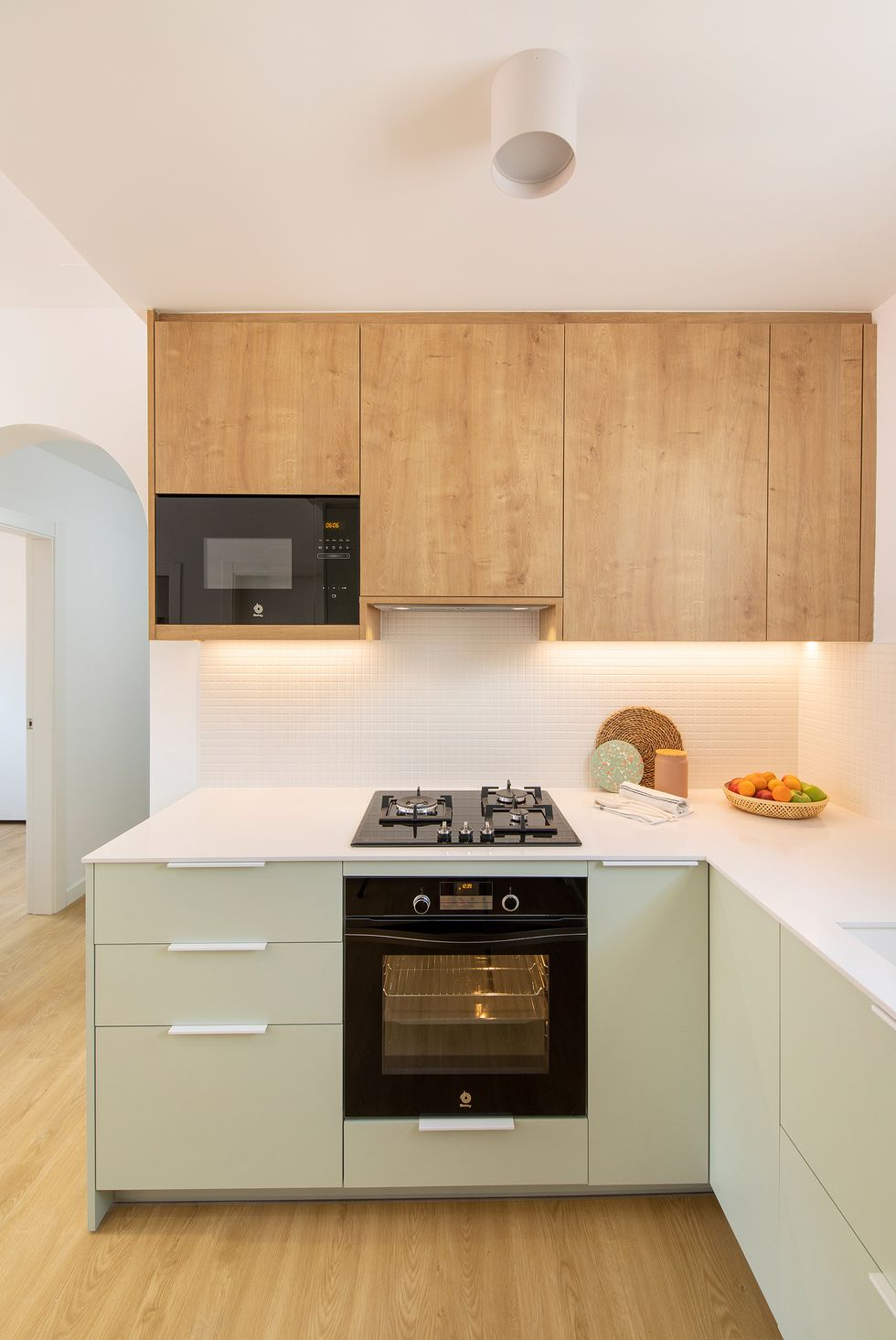 cocina de color verde empolvado con armarios superiores de madera